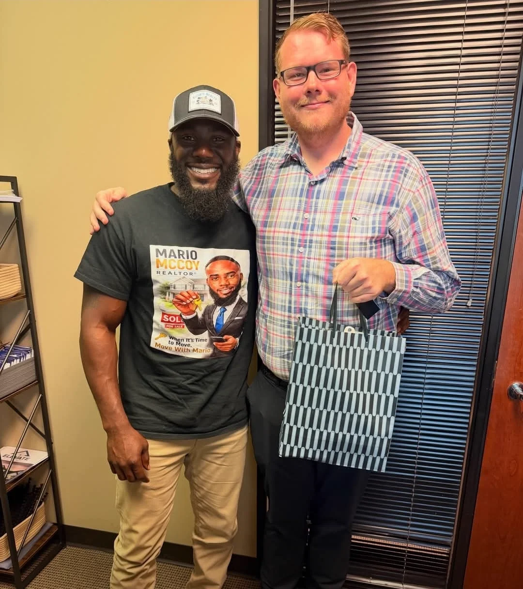 Mario in his Move With Mario shirt with a client holding a closing gift